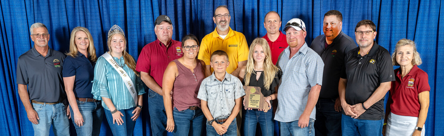 Missouri State Fair Farm Family honorees from Gasconade Country include (in front, from left) Cindy, Deegan, Harper, and Cody Priess of Hermann. Joining the Priess family were MU and Missouri State Fair officials (in back, from left) Mark Wolfe, Missouri State Fair director, Christine Chinn, Missouri Department of Agriculture director, Kelsey Miller, state fair queen, Ted E. Sheppard, state fair commissioner, Chad Higgins, interim vice chancellor for MU Extension and Engagement, and interim chief engagement officer UM System, Garrett Hawkins, Missouri Farm Bureau president, Harold “Byron” Roach,fair commissioner, Rob Kallenbach, MU associate dean of Extension and senior program director of Agriculture and Environment, and Nikki Cunningham, fair commissioner.